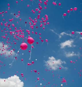 Pink Balloons rising into the blue sky symbolize Breast Cancer Awareness Month.
